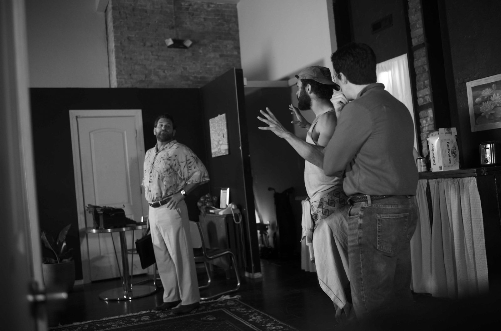 True West: Saul stands with his briefcase as Lee gestures and Austin hides behind him